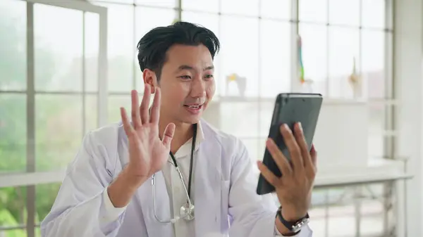 Νεαρός Ασιάτης Γιατρός Κουνώντας Χέρι Έχοντας Εικονικό Βίντεο Κλήση Απευθείας Royalty Free Εικόνες Αρχείου