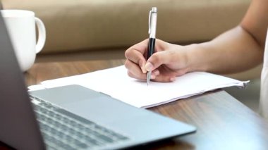 Stock video of a woman writing on paper.