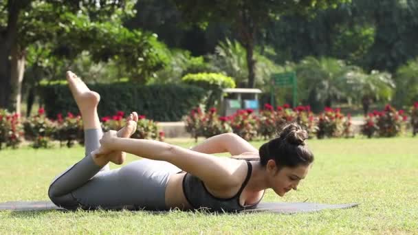 Flexibel Ung Kvinna Gympakostym Utför Bågen Poserar Övning Stunder Liggande — Stockvideo