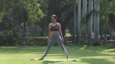 Utthita Trikonasana poz veren genç bir kadının videosu.