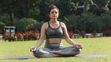 Video footage of a fit woman doing Anulom Vilom Pranayama, or alternate nostril breathing exercise.