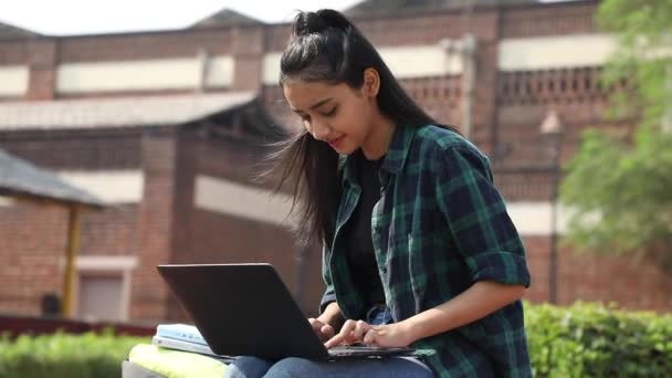 一个印度女大学生坐在大学校园里 在笔记本电脑上工作 看着摄像机的视频 — 图库视频影像