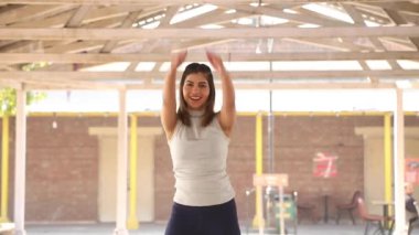 Video footage of fit woman performing pull over aerobic exercise.