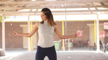 Video of Indian woman performing chest fly exercise.