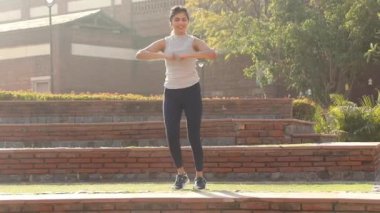 Video footage of woman doing chest cardio workout.