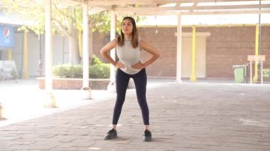 Video of fit woman performing hip rotation exercise by making circles both going clockwise and then counterclockwise (forward and then backward).