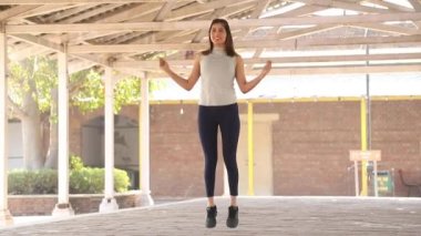 Video of elegant woman doing jump rope exercise for weight loss exercise.