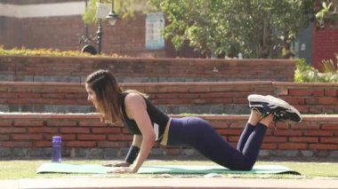 Video of fit woman performing knee push up exercise in fresh air.