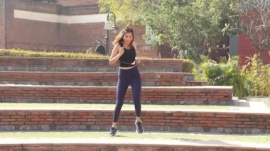 Video of slim woman in gym outfit doing marching workout exercise.