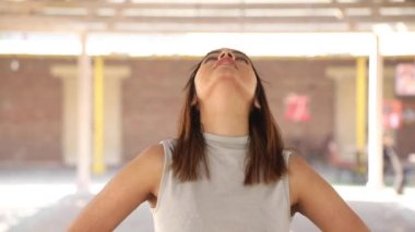 Video of Indian fit girl rotating her neck warming up before workout exercise.