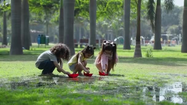 Vídeos Ação Três Crianças Brincando Com Barcos Papel Coloridos Parque — Vídeo de Stock