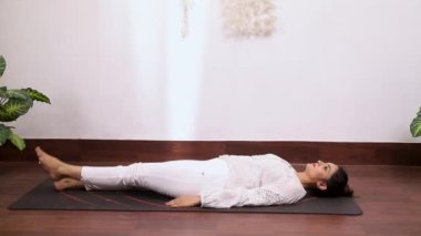 Alternatif bacak gösterisi yapan kadın videosu Ardha Halasana stresi azaltmaya, diz ağrısını ve boyun ağrısını azaltmaya yardımcı oluyor.