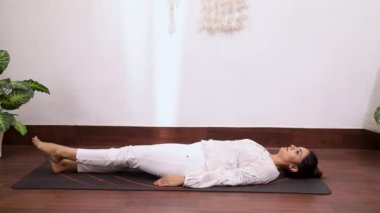 Kadının alternatif bacak hareketi videosu Ardha Halasana, bu egzersiz uyluk ve kalça kaslarını güçlendirir