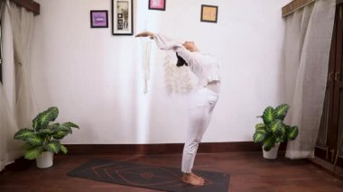Kadının Surya Namaskar 'ı sahnelediği, kilo vermesine yardımcı olan ve kas ve eklemleri güçlendiren video.