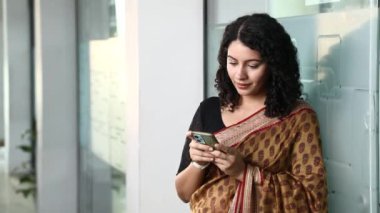 Çalışan Kadın 'ın ofis molasında çekilmiş videosu kamerada akıllı telefon ekranını gösteriyor.