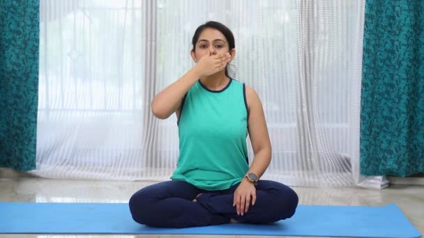 アヌロマプラヤマまたは交互の鼻孔呼吸運動を行う女性のストックビデオ — ストック動画