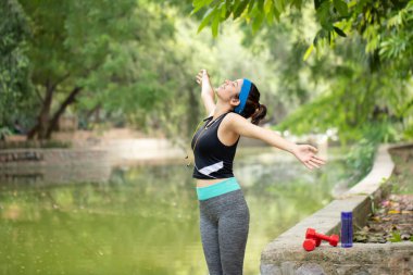 Çekici bir kadın nehir kenarında temiz hava soluyor.