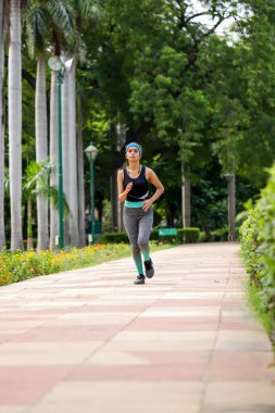 Yeşil Park 'ta spor kıyafetleriyle koşan bir bayan. 