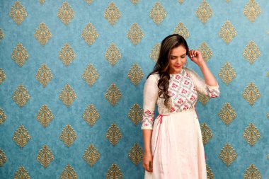 Utangaç bir model utangaç bir şekilde poz veriyor ve yere bakıyor.