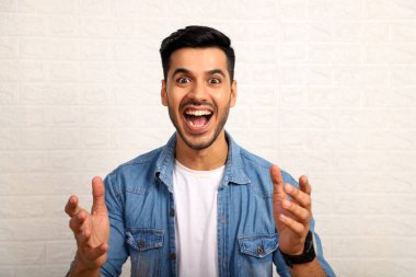 Aroused Man In Denim Jacket With Surprised Face Expression And open mouth is posing clipart