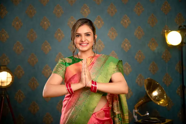 一位穿着印度萨里衫的可爱女模特坐在椅子上 在摄像机前微笑着 免版税图库图片