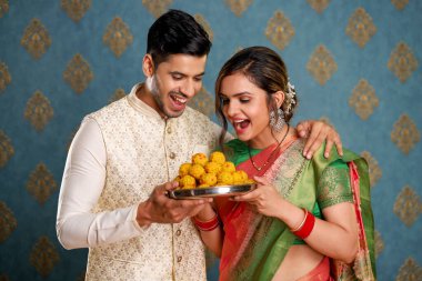 Geleneksel kıyafet giymiş bir çiftin Diwali kutlamasında elinde bir tepsi ladoo...