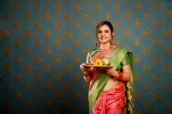 在迪瓦里节的时候 漂亮的家庭主妇手里拿着一个迪雅盘子 同时还穿着印度传统的萨里衫 图库图片