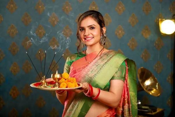 亚洲可爱的模特笑着拿着南瓜盘 穿着传统的印度莎丽服参加Diwali节 图库图片