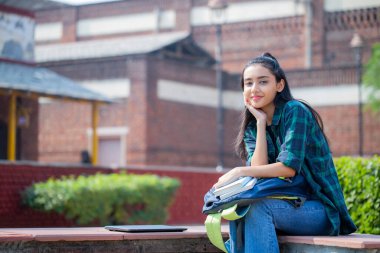 Charming lady, smiling and sitting with her hand under her chin