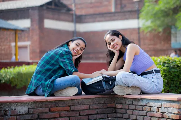 Two innocent friends looking at the camera with both hands under their chin