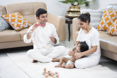 Evde sabun köpüğüyle oynayan bir aile. 