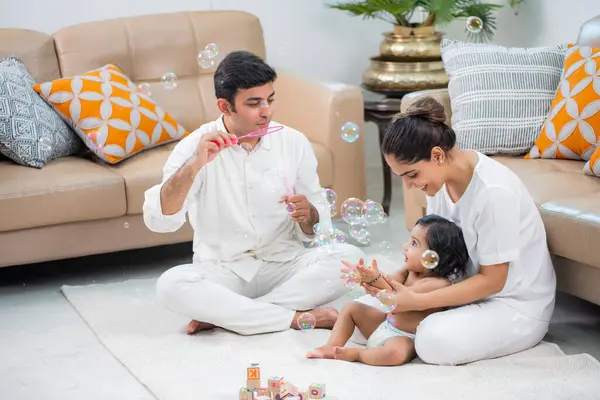 Ebeveynler erkek çocuklarıyla sabun köpüğüyle oynuyorlar.