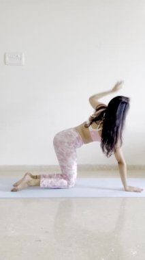 Yoga yapan sağlıklı bir kızın, chakrasana veya tekerlek pozu gibi poz verdiği bir video..