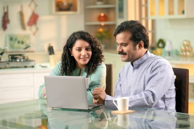 Genç çifti sevmek, dizüstü bilgisayar kullanmak, kahve içmek, hafta sonunun keyfini çıkarmak.