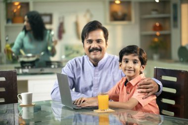 Baba ve oğul kameraya bakarken gülümsüyor