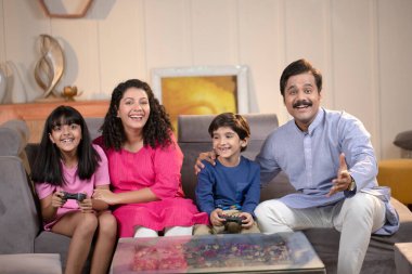 Abim ve ablam video oyunu oynarken eğleniyorlar.