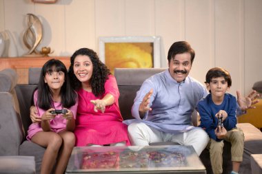 Mutlu bir aile video oyunu oynuyor ve evde eğleniyor.