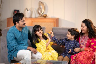 Yaramaz çocuk Rakhi sırasında kız kardeşini besliyor.