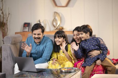 Baba ve Oğul 'un kızı laptoptan video görüşmesi yaparken akrabalarına merhaba diyor.