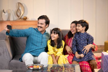 Annem ve babam çocuklarla selfie çekiyorlar. 