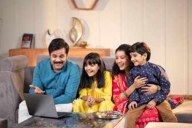 Ev bilgisayarında video görüşmesi yaparken aile birisiyle konuşuyor.