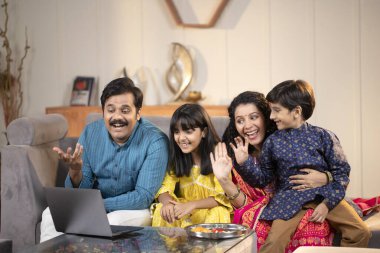 Gülümseyen Aile, Akrabalarıyla Konuşmak için Konferans Video Çağrısı ile Laptop Kullanıyor 