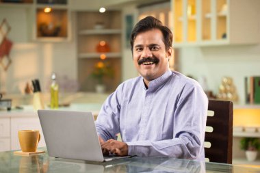 Yetişkin erkek ağzı açık gülümsüyor ve önüne bakıyor.