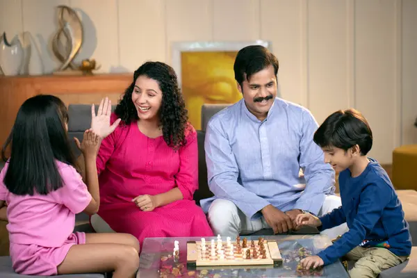 Harika bir aile evde satranç oynuyor.