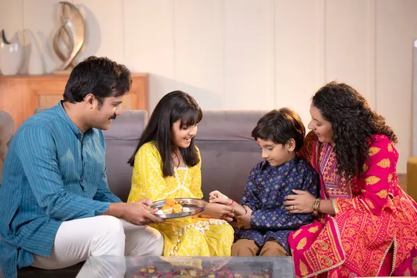 Raksha Bandhan kutlaması sırasında Rakhi 'yi kardeşine bağlayan kız.