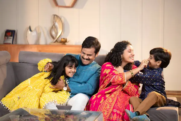 Modern Nükleer Aile oturma odasında kanepede oturmuş eğleniyor.