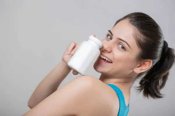 Güzel, bekar bir kadının tablet şişesini gösteren yakın çekim görüntüsü.