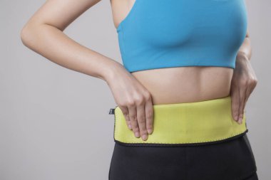 Elleri belinde duran genç bir kadının göbeğine uygun.