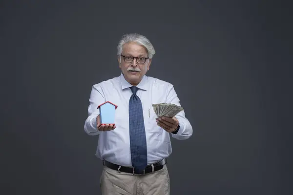 Ciddi yüzlü kıdemli Asyalı adam parasını ve oyuncağını vermeye çalışıyor.