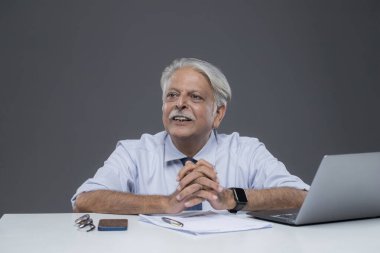 Ofiste oturan üst düzey bir pazarlama yöneticisi ellerini masaya koyuyor.